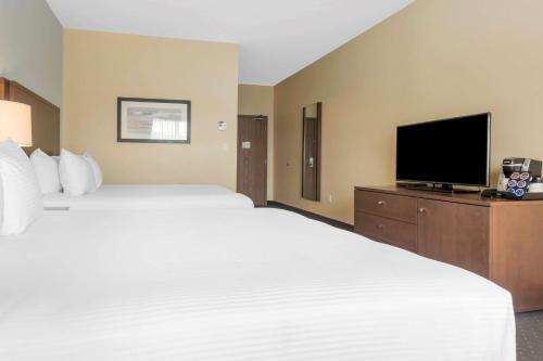 a hotel room with two beds and a flat screen tv at Best Western Plus Liverpool Hotel & Conference Centre in Liverpool
