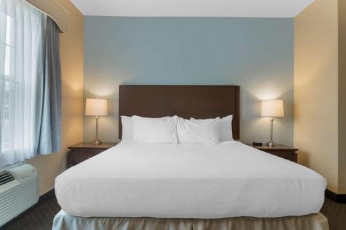a large bed in a hotel room with two lamps at Best Western Plus Liverpool Hotel & Conference Centre in Liverpool