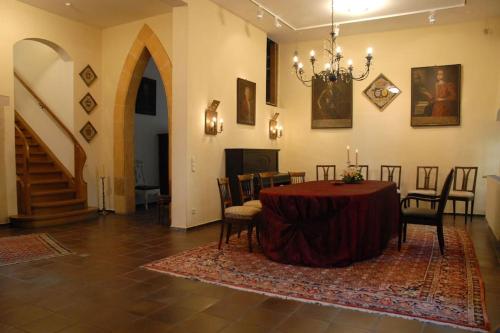 a dining room with a table and chairs and a staircase at Haus Keppelborg: ZI Antonia mit Kirchplatzblick in Heek