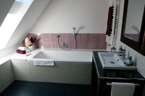 y baño con bañera y lavamanos. en Haus Keppelborg: ZI Antonia mit Kirchplatzblick, en Heek