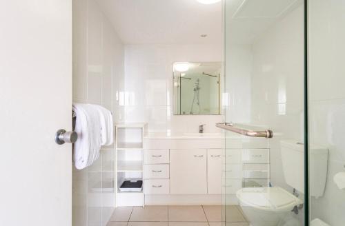ein weißes Bad mit einem WC und einer Glasdusche in der Unterkunft Spacious & Magnificent Views Apartment in Gold Coast