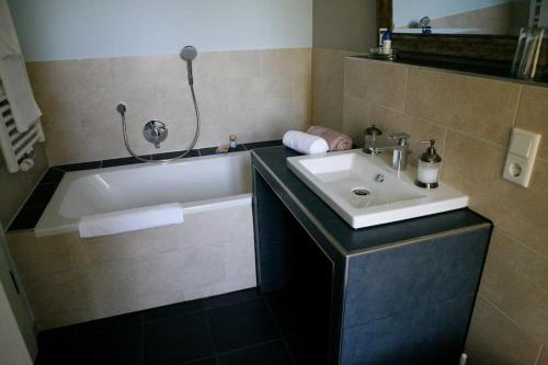 a bathroom with a sink and a bath tub at Haus Keppelborg: ZI Ferdinand mit Rosengartenblick in Heek