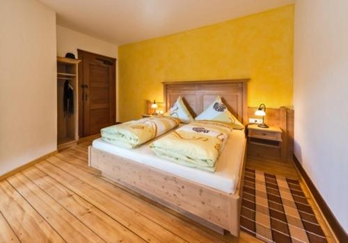 ein Schlafzimmer mit einem großen Bett mit gelben Wänden in der Unterkunft Landhaus Christophorus in Forbach