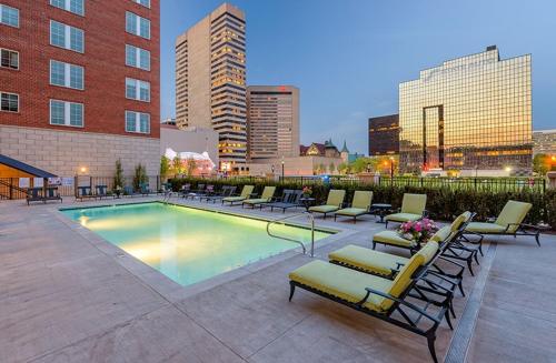 a swimming pool with lounge chairs and a building at King Size with OSU Theme! in Columbus
