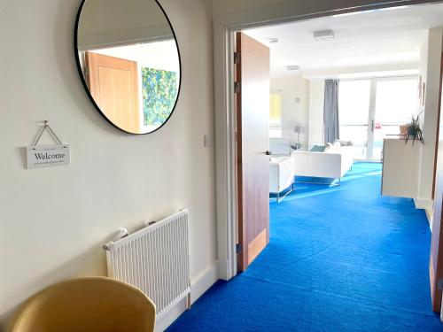 a hallway with a mirror and blue carpet at Quay & Sea View Spacious Modern Secure Parking in Poole