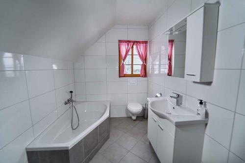 La salle de bains blanche est pourvue d'une baignoire et d'un lavabo. dans l'établissement Holiday home in Mirna Pec Kranjska Krain 43928, à Mirna Peč