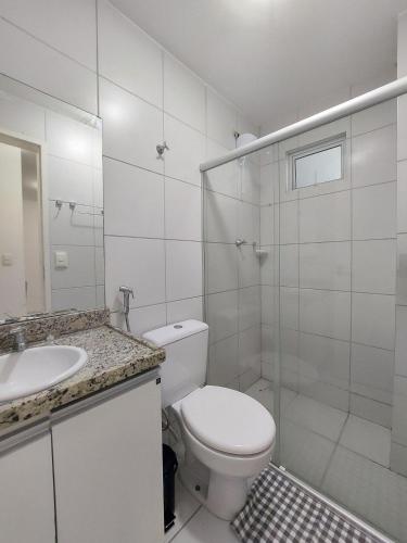 a white bathroom with a toilet and a sink at Apê encantador no Ed.. Manhattan home service 1703 in Caruaru