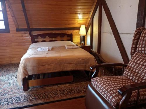 1 dormitorio con 1 cama y 2 sillas en una habitación en Casa da Dine - Cama & Café, en Campos do Jordão
