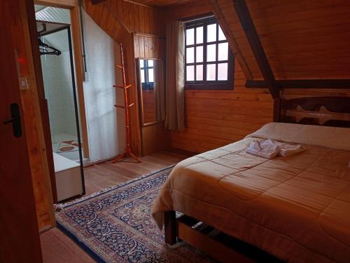 1 dormitorio con 1 cama en una habitación de madera en Casa da Dine - Cama & Café, en Campos do Jordão