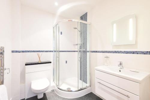 een badkamer met een douche, een toilet en een wastafel bij Glas Mor in Carbis Bay