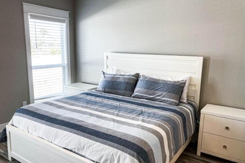 a bedroom with a bed with a blue and white striped blanket at A Slice of Pura Vida in Mexico Beach