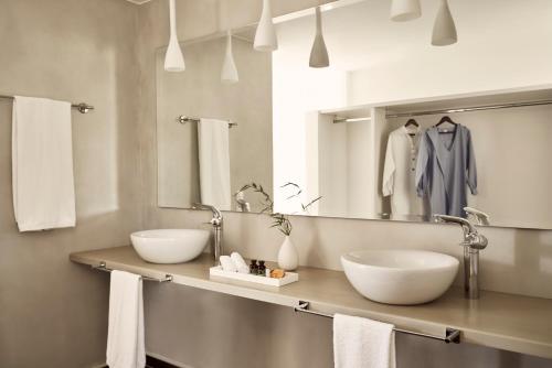 a bathroom with two sinks and a mirror at Yria Island Boutique Hotel & Spa in Parasporos