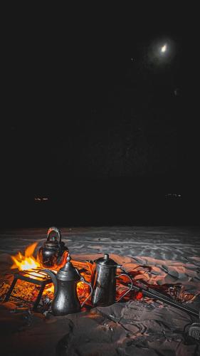 a campfire with two tea pots on top of it at Syndebad desert camp in Wadi Rum