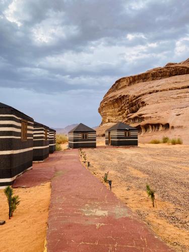 a row of huts in the desert near a cliff at Syndebad desert camp in Wadi Rum