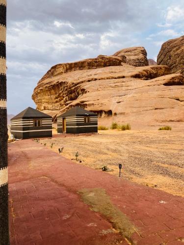 a building in the desert next to a rock formation at Syndebad desert camp in Wadi Rum