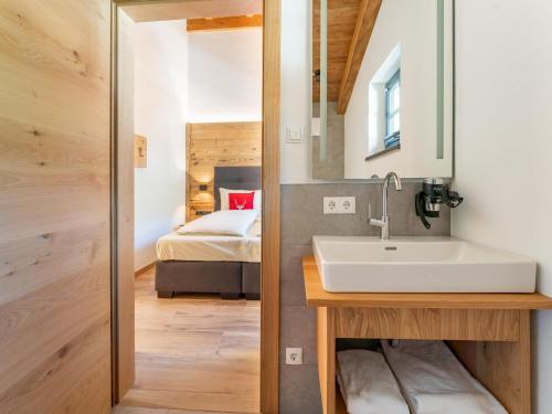 La salle de bains est pourvue d'un lavabo et d'un lit dans la chambre. dans l'établissement Pinzgau Lodge 1A 1B, à Wald im Pinzgau