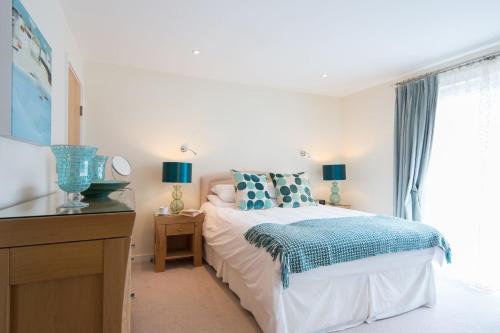 a white bedroom with a bed and a window at Ocean View in Carbis Bay