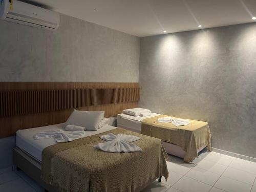 a hotel room with two beds and two tables at Suítes&Flats MarBello in Maragogi