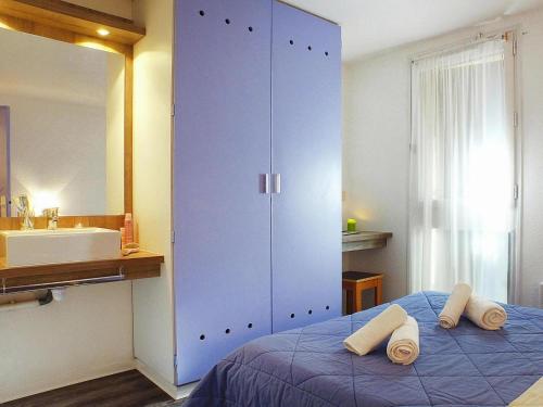 - une chambre avec une grande armoire bleue et des serviettes sur un lit dans l'établissement Holiday home for 6 guest with sea view, à Soulac-sur-Mer