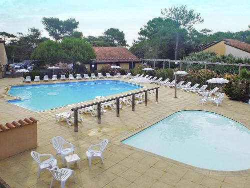 - une grande piscine avec des chaises et un bouquet d'équipements dans l'établissement Holiday home for 6 guest with sea view, à Soulac-sur-Mer