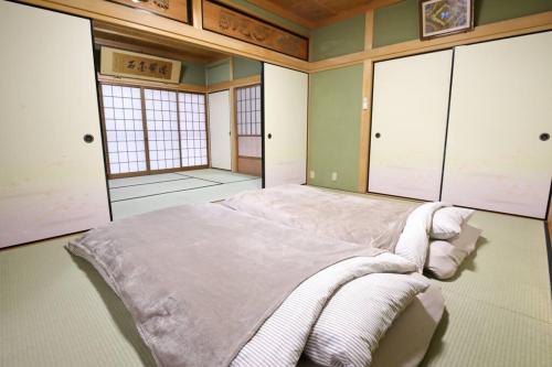 um quarto com uma cama grande e toalhas em HAT byakugoji, Japanese traditional fireplace　HAT白毫寺　自然豊富な別荘地にある囲炉裏付き一軒家 em Nara