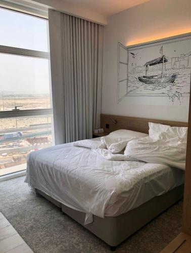 a bedroom with a bed and a large window at Nice Dubai in Dubai
