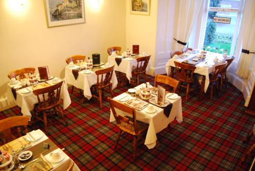a restaurant with tables and chairs with white tablecloths at Royston Guest House Inverness in Inverness