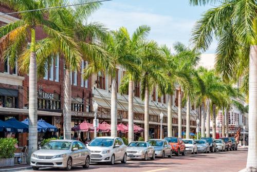 a row of cars parked on a street with palm trees at Lovers Key Resort 1105 in Fort Myers Beach