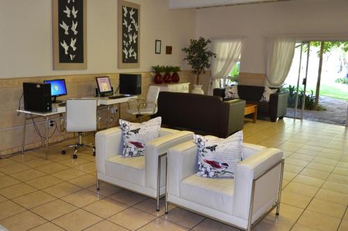 a living room with two chairs and a desk at Dove's Nest Guest House in Kempton Park