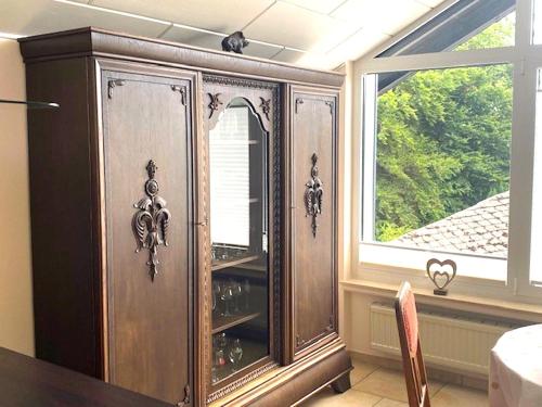 a large wooden cabinet in a room with a window at Jünkerath Romantic Garden Stay in Jünkerath