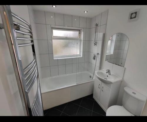 a bathroom with a tub and a sink and a toilet at Hendon Homestay in Hendon