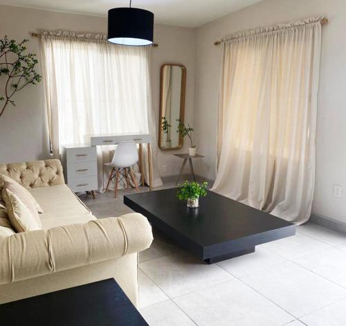 ein Wohnzimmer mit einem Sofa und einem Tisch in der Unterkunft Casa Magnolia 2 in Ciudad Madero