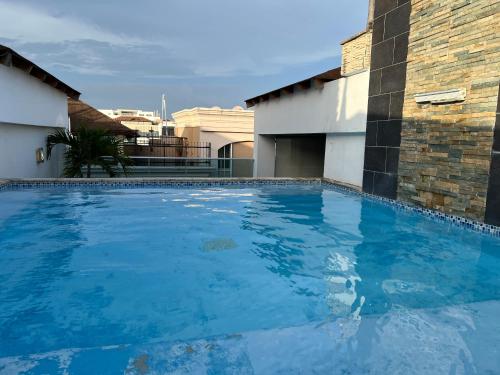 una gran piscina azul junto a un edificio en Exclusivo Apto Piscina Bella Vista Centro de Ciudad! en Santo Domingo