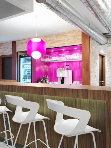 a bar with white stools and pink walls at BEST WESTERN Hotel Brussels South in Ruisbroek