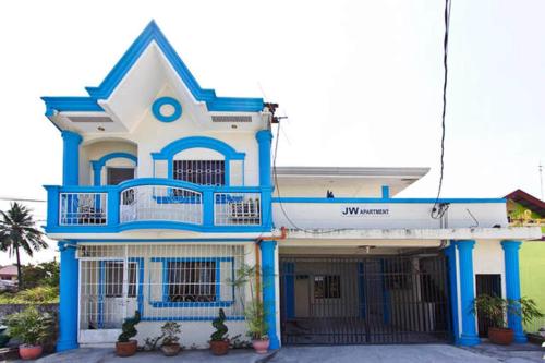 a blue and white house with a balcony at JW Apartments in Angeles