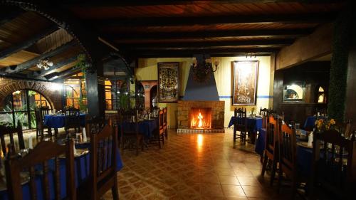a dining room with tables and chairs and a fireplace at Hotel Palacio de Moctezuma in San Cristóbal de Las Casas