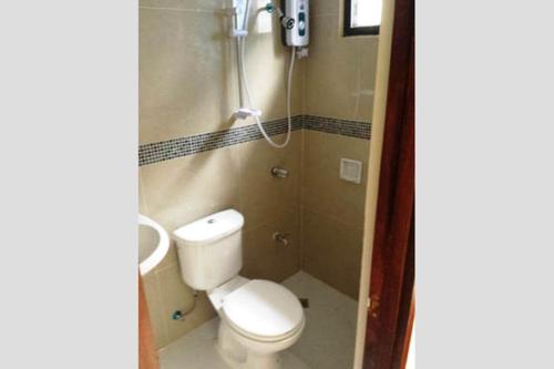 a small bathroom with a toilet and a shower at JW Apartments in Angeles