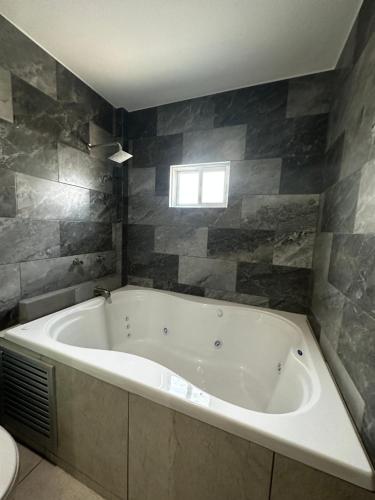 a bath tub in a bathroom with a window at Casa Picacho by Cobo´s in Aguascalientes