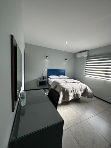 a bedroom with a bed and a desk with a television at Casa Picacho by Cobo´s in Aguascalientes