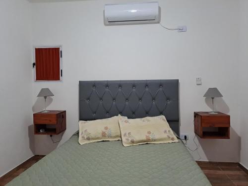 ein Schlafzimmer mit einem Bett mit zwei Nachttischen und zwei Tischen in der Unterkunft CABAÑA LA HERRADURA 14 in San Roque