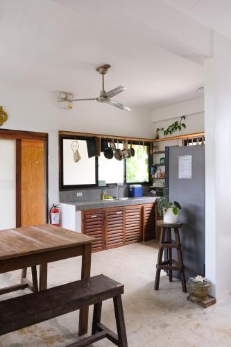 a kitchen with a wooden table and a kitchen counter at Secret Spot Siargao in General Luna