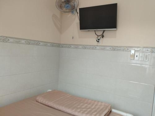um quarto com uma cama e uma televisão de ecrã plano na parede em Homestay 195/4 em Ấp Khánh Phước (1)