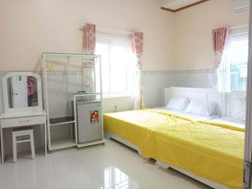 um quarto com uma cama com uma colcha amarela em Homestay 195/4 em Ấp Khánh Phước (1)