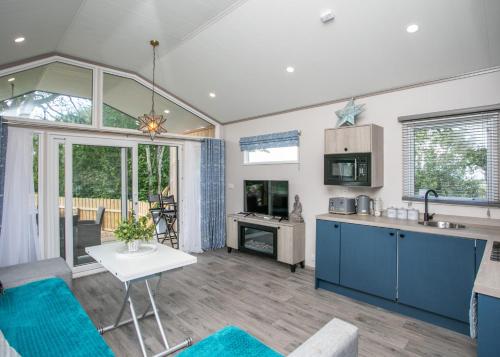 a kitchen and living room with blue cabinets at Blaithwaite Country House Estate in Wigton