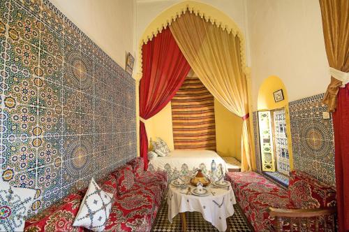 a room with a table and a bed in it at Riad Dar Jabador in Sale