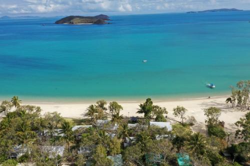 an aerial view of a beach with palm trees and the ocean at Great Keppel Island Hideaway in Great Keppel