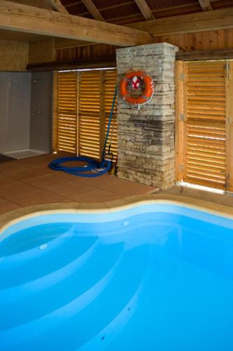 a large swimming pool in a room with a clock at Růžová chalupa u Šimánků in Rtyně v Podkrkonoší