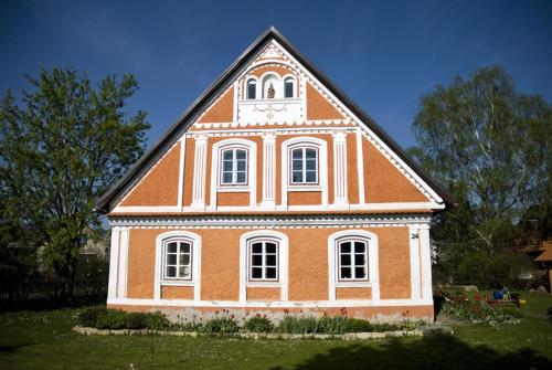 a large house with a clock on the top of it at Růžová chalupa u Šimánků in Rtyně v Podkrkonoší