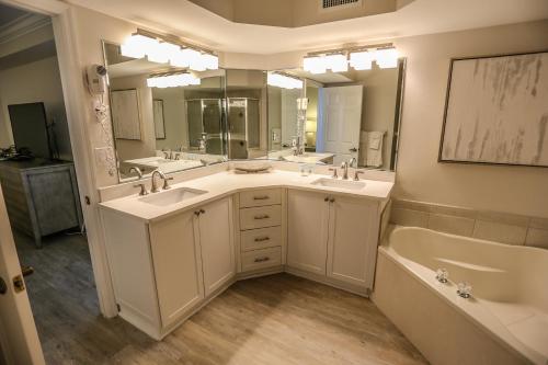 y baño con 2 lavabos, bañera y bañera. en Lovers Key Resort 404, en Fort Myers Beach