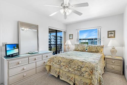 um quarto com uma cama e uma cómoda com um espelho em Estero Cove 341 em Fort Myers Beach